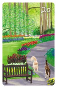 20 Der Park im Magic Cat Lenormand. Zwei Straßenkatzen begenen sich in einem gepflegten Park mit Blumen und einer Parkbank.