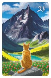 21 Der Berg im Magic Cat Lenormand. Eine rote Katze beobachten von einem Felsen aus einen sehr hohen Berg. Vor ihr befindet sich ein Tal mit Wäldern, Blumen und einem See.